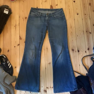 lågmidjade bootcut jeans - innerbenslängd:81  jättesnygga bootcut jeans perfekta för hösten!! snygg blå färg och röd detalj på fickan!!  säljer pga att de inte passade. sista bilden är från den gamla säljaren