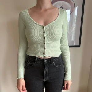 Grön croppad kofta - Grön croppad kofta från H&M. Storlek S. Aldrig använd, lapp kvar, men har två lösa små trådar på insidan. Inget som syns på utsidan. 
