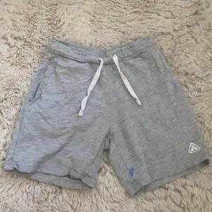 Ett par grå lite längre mjukis shorts i storlek 122/128, de har en liten blå fläck som man ser på bild två men annars väl andvända