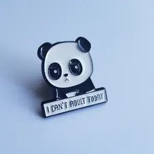 Metalpin föreställande en panda som är trött på vuxenlivet