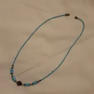 Ljusblått halsband med plastpärlor