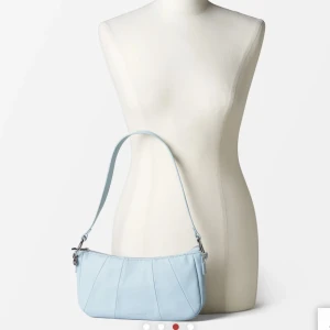 Blå baguetteväska - Säljer en helt ny väska från Carin Wester, med plasten kvar på. Nypris 400 kr. Säljer för 150 kr, men pris kan diskuteras! 