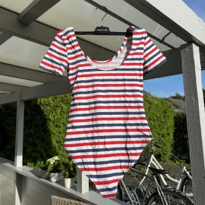 Randig sommar tshirt - Jättefin randig sommar body-tshirt från hm! Fint skick , elegant öppen vid axlarna och brösten samt tight över kroppen. 