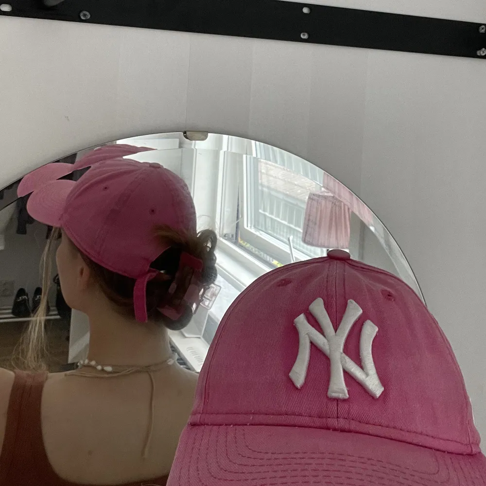 En New York Yankee keps med en washed out rosa färg. Använd men fortfarande i bra skick. Justerbar där bak.. Övrigt.