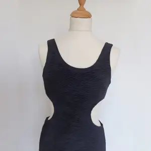 Svart ribbad bodycon klänning med cutouts vid midjan. Utmärkt skick. Storlek XS.