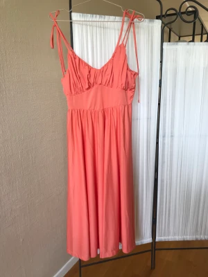 Korallfärgad klänning  - Provad men aldrig använd. Hämtas i Huddinge. 