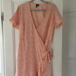 Omlottklänning, S - En orange omlottklänning från VeroModa köpt för ca 400:-, säljer för 150:-. Storlek S, (passar 36-38). Säljer tyvärr för att den blivit för liten för mig. Köparen står för frakten🧡