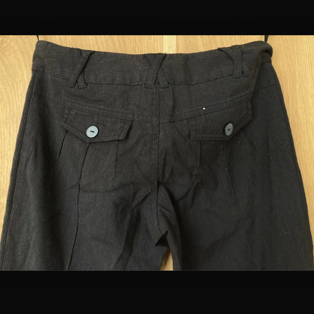 Mörkbruna Kostymbyxor i ”jeansmaterial” med tunna kritränder. Storlek 8 så skulle uppskatta att dem är en 36 i svensk storlek.. Jeans & Byxor.
