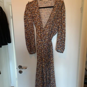 Långklänning från indiska - Jättefin klänning i omlottmodell från indiska, använd ett fåtal gånger så väldigt fint skick. strl S men passar även en M skulle jag säga☺️