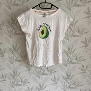  T-shirt  - En vit T-shirt med en avokado på.  När jag köpte den köpte jag den som ett pyjamasset men byxorna är borta. Så denna vita T-shirt är en pyjamas tröja, men man kan ha den som en vanlig T-shirt ochså.