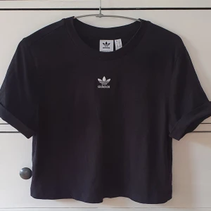 Croppad t shirt Adidas - En croppad adidas t shirt med vikta ärmar, oanvänd. 