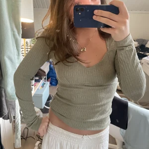 Grön långärmad tröja  - Jättefin långärmad tröja med lite detaljer framtill, och lite fyrkantig halsringning🙏🏻 Superfin grön färg, skriv vid intresse eller för fler bilder😇😇🪩