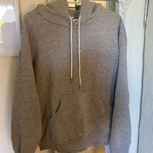 En ljusgrå (ljusare i verkligheten än på bilden) basic hoodie i storlek M. Knappt använd, fint skick. Jätteskön. 