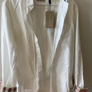 Burberryskjorta vit fint skick storlek medium  - Fin skjorta med tags köpt på NK. Tyvärr för liten för mig. Nyskick 