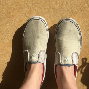 Vans - Slip-om band. Vita med röda och blåa detaljer. Använda men i bra skick. 