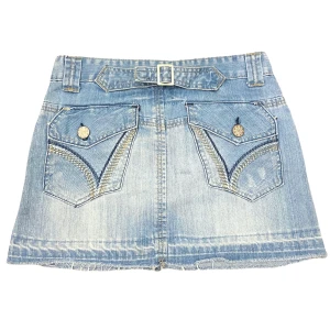 Lågmidjad Vintage Kjol - Varan kan köpas direkt på vår hemsida, ettmarke.se Modell: Lågmidjad. Färg: Blå. Storlek: 158 enligt lapp. Uppskattad europeisk storlek 34. Midja platt rakt över: 36 cm Totallängd (från midjan): 32,5 cm Skick: Fint skick med få tecken på användning. 