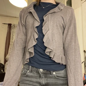 Grå kofta! - En fin grå kofta i storlek L med volanger runt hela. Väldigt fint skick och inte alls använd mycket då det blev fel storlek där av oxå varför jag säljer den💗 Köpte den för 200kr, Säljer nu för 100 kr inklusive frakt!
