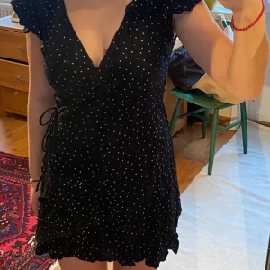 Prickig klänning  - Säljer min all favorit klänning som tyvärr blivit för liten💔 klänningen är i ett så skönt matreal och klänningen knyts omlott och kan väljas om man vill ha knuten bak eller sidan på höften🌹💘