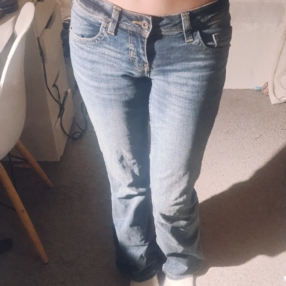  Blå lågmidjade jeans med knappar på bakfickorna, storlek 34❤ Jag är 167, dem är perfekta i längden. Har andvänt dem få gånger💕. Jeans & Byxor.