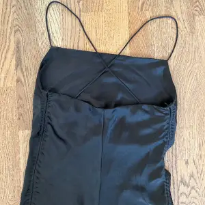 Supersnygg svart siden klänning med tie-back! Har även resår på sidorna, aldrig använd ✨