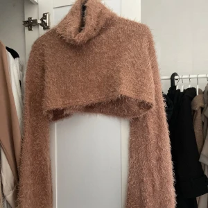 Croppad mjuk tröja  - Super mjuk och fin croppad tröja. Turtle neck och långa utsvängda ärmar. Man kan se materialet på andra bilden. Använd 2-3 gånger. 