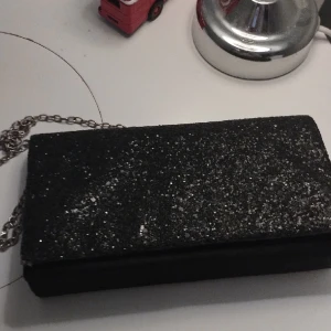 Svart väska - En glittrande svart väska och den är knappast använt 