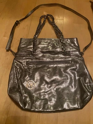Michael kors väska - Michael kors convertible tote bag/crossbody, gently used. adjustable straps. Stainless steel accents. Silver color. Genuine leather. Retail price $258 