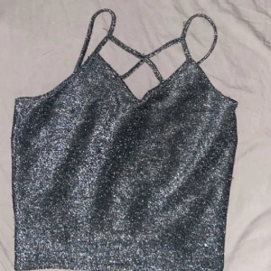 Glittrig topp  - En glittrig top från new look. Använd en gång. För fler bilder kontakta mig 