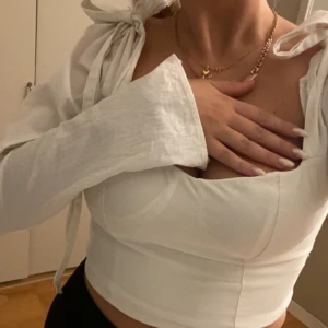 Vit blus  - Korsett liknande topp med knytning på axlarna. Linne liknande material.   Superfin men aldrig använd tyvärr. Köpt på HM. Storlek 40 men tröjan är liten i storleken så den skulle passa 38/36. Nypris 399 säljer för 150kr+frakt💕💕