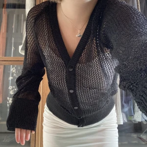 nätkofta - svagt glittrig och med massa små hål. perfekt att klä upp på fest eller klä ned på vardagen. när den är knäppt går den att använda som tröja med en bh under bara