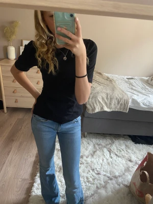 Svart volang t-shirt - Säljer denna t-shirten med volang från Vero Moda. Är aldrig använd då prislappen är kvar och är i  mycket bra skick. Denna är likadan som min gröna i min profil om ni vill titta på ett annat exempel. 