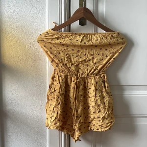 Jumpsuit  - Armlös jumpsuit från Hollister. Gul med röda blommor. 