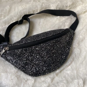 Magväska - Säljer denna supersnygga magväska! Använde den på lollapalooza och andra konserter, tänkte även ha den på the eras tour men köpte en annan, perfekt om man ska stå länge men vill va glittrig! Jätteskön och praktisk, midnights vibes. Kom privat för info <3