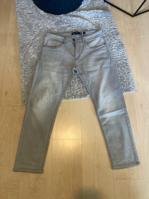 Gråa jeans - Gråa jeans som knappt använts. Max varit använda 2-3 gånger. Storleken på dessa är W34 L30 men skulle själv säga att storleken är W32-33 L32 då jag har den storleken och den passade mig perfekt. Storleken var lite annorlunda på detta jeans.