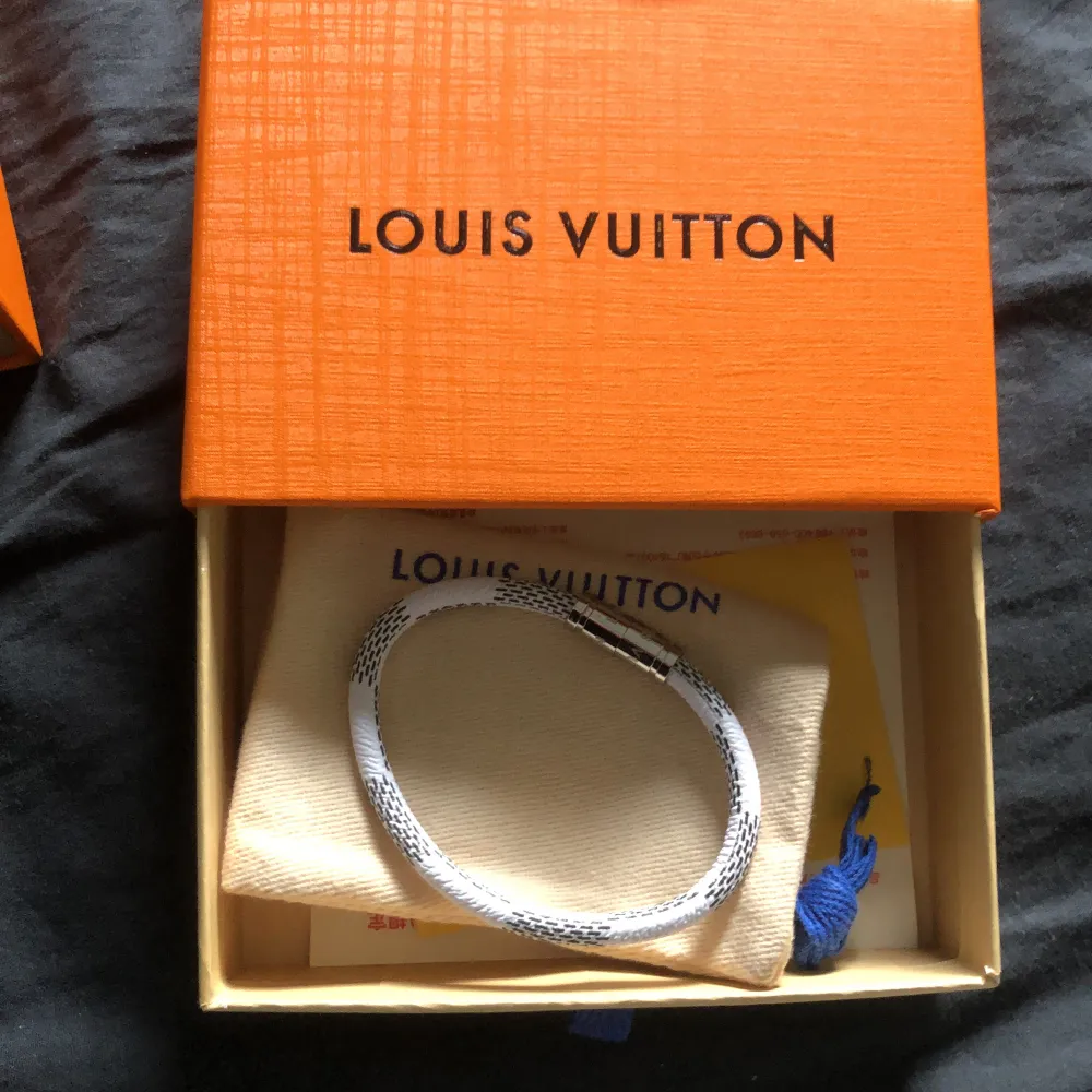 Ett stiligt 1:1 Louis Vuitton-armband i vitt. Sprillans nytt, inga tecken på användning. Låda och dustbag medföljer. Metallen är silverfärgad. Passar handleder under 20 cm i omkrets. Accessoarer.
