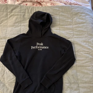 Peak performance hoodie - Jättefin svart peak performance hoodie, är storlek 170 men passar mig med XS väldigt bra, inte använd så mycket så nyskick, väldigt skön, köpt för 700kr 