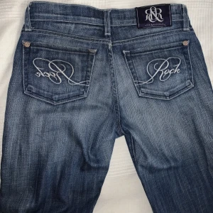 Lågmidjade bootcut jeans  - Säljer nu mina så snygga vintage Lågmidjade bootcut jeans då jag inte längre använder dom… Står ingen storlek men passar mig som är mellan 34-36. Så snygga bakfickor där det står ”rock” på. Köparen står för frakt 💗