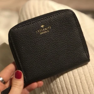 L’ETERNITE plånbok - Svart söt liten plånbok i märket L’ETERNITE som jag inte minns vart jag köpt den. Bra skick.