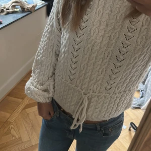 Stickad tröja  - Super fin stickad tröja med en extra detalj runt midjan. 