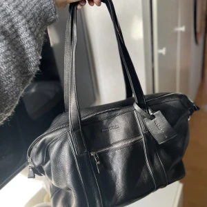 Svart Marc o Polo Weekend Bag - 45*20*30 cm stor weekend bag i läder från Marc o Polo. Aldrig använd. Väldigt rymlig med många innerfack. Justerbar axelrem och märkes-tygbag tillkommer och ingår i priset. Skriv privat till mig för mer info!