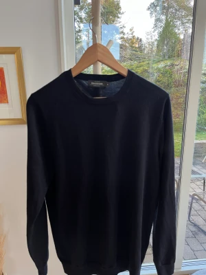 Mörkblå stickad tröja - En stickad tröja i merinoull från dressman, väldigt bra skick.