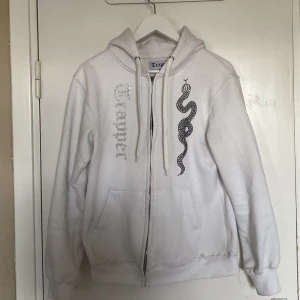 Made by trappers zip hoodie - Hej, jag säljer nu min Made by trappers zip hoodie då den inte kommer till användning. Tröjan är i hyfsat bra skick däremot är dragkedjan lite sönder men det är inget som syns vid användning. Storleken är M men sitter mer som S. 