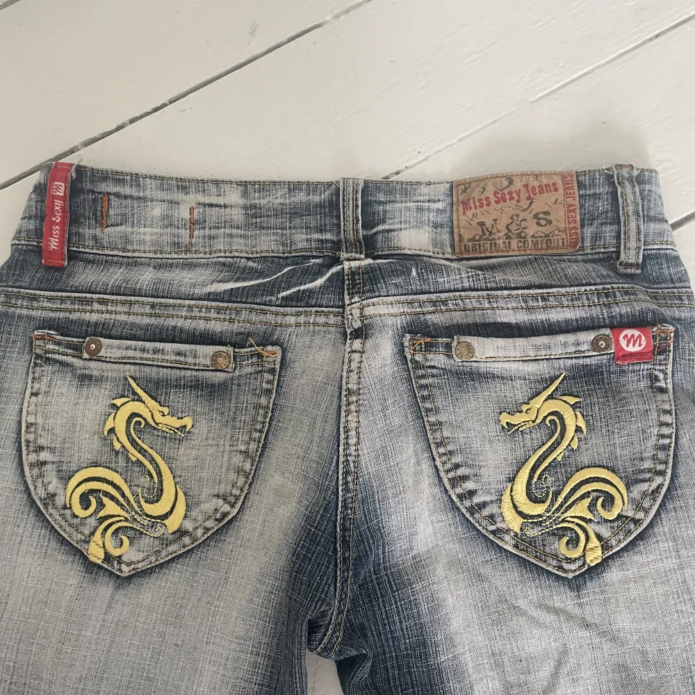 lågmidjade utsvänga jeans med unika fickor och cool blekning. tidigare säljare har klippt av en del på benen men ändå i gott skick. Midjemått: ca 35cm innerbenslängden: ca 69cm. Jeans & Byxor.