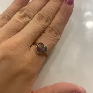 Ring - En guld ring med ett hjärta. Det ska vara en sån här mood ring asså att den ändrar färg beror på vilket humör man är på. Använt den några gånger, den är i bra skick och bekväm. Tror den är från h&m. Storleken finns i sista bilden.
