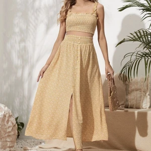 Set med topp och kjol - Fint blommigt gravidset med top och lång kjol. Toppen är smockad och har volang på axelbanden. Kjolen har resår upptill, knappar framtill och slits. Aldrig använt. Storlek M. 