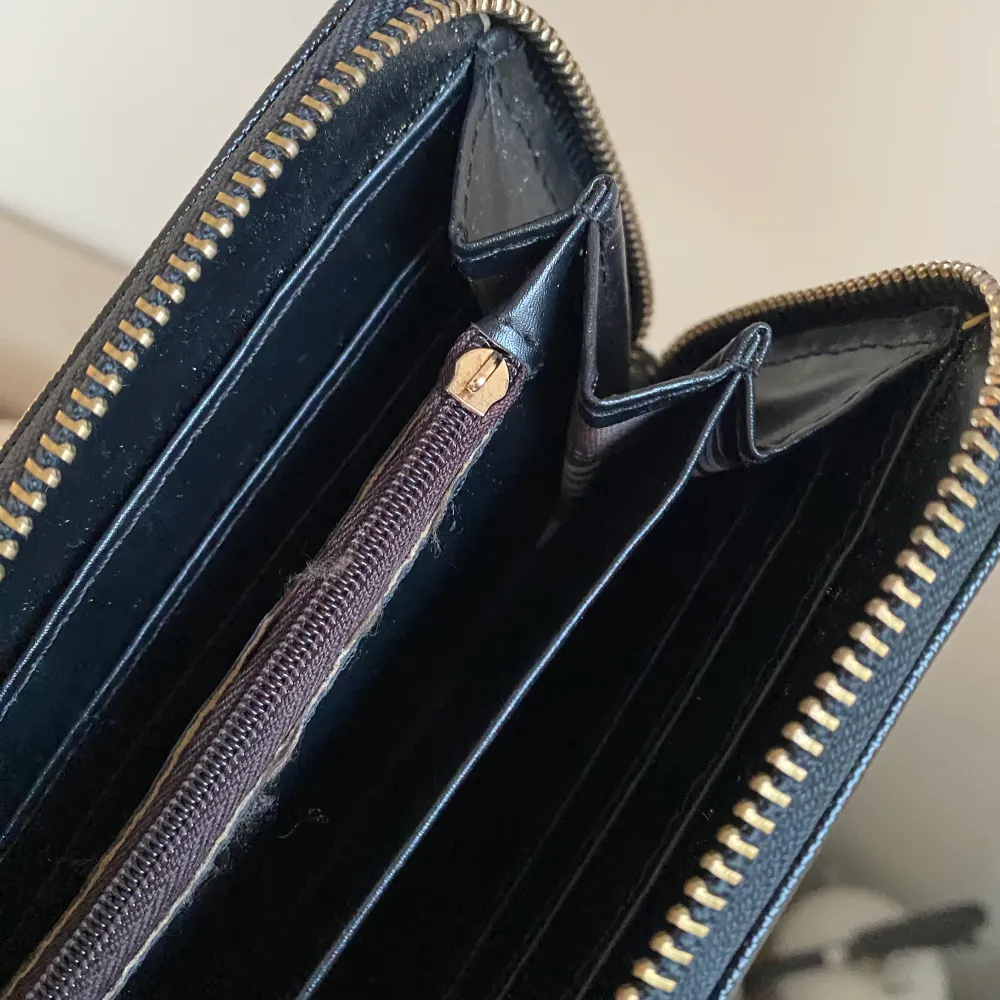 Plånbok från Michael Kors. Har hängt med ett tag så några små slitningar och dragkedjan till myntfacket är sönder. . Asusteet.