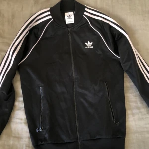 Adidas tröja med dragkedja - Säljer min adidas sst top oönskad födelsedagspresent har bara använts typ 2 gånger och är i jättebra skick. Pris kan diskuteras