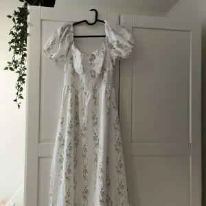 Vit sommarklänning  - En mycket vacker vit klänning med gröna detaljer och puffärmar. Oanvänd, skriv privat för fler bilder. Kontakta innan du trycker på ”KÖP NU”