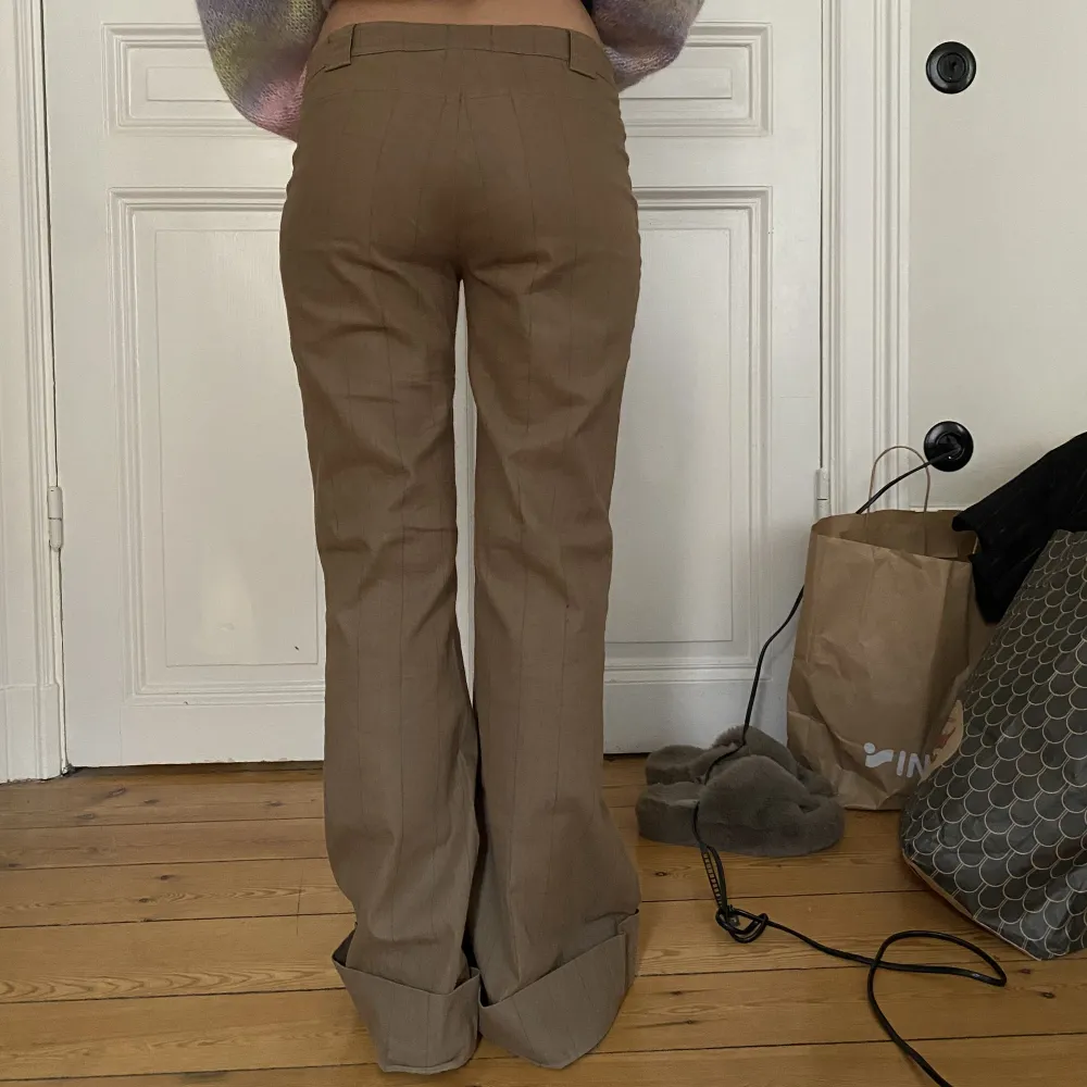 Brun/beiga lågmidjade kostymbyxor med bootcut. Jättesnygga till tex uggs och en stickad tröja🥰. Jeans & Byxor.