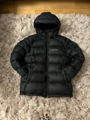 Peak performance W down frost jacka - Säljer min Peak performance jacka pga den är för jag ej använder den längre,  Det är en Dam jacka. Den passar ungefär vemsomhelst för att man kan croppa den där nere! Ny pris 4200kr Mitt pris 2500kr
